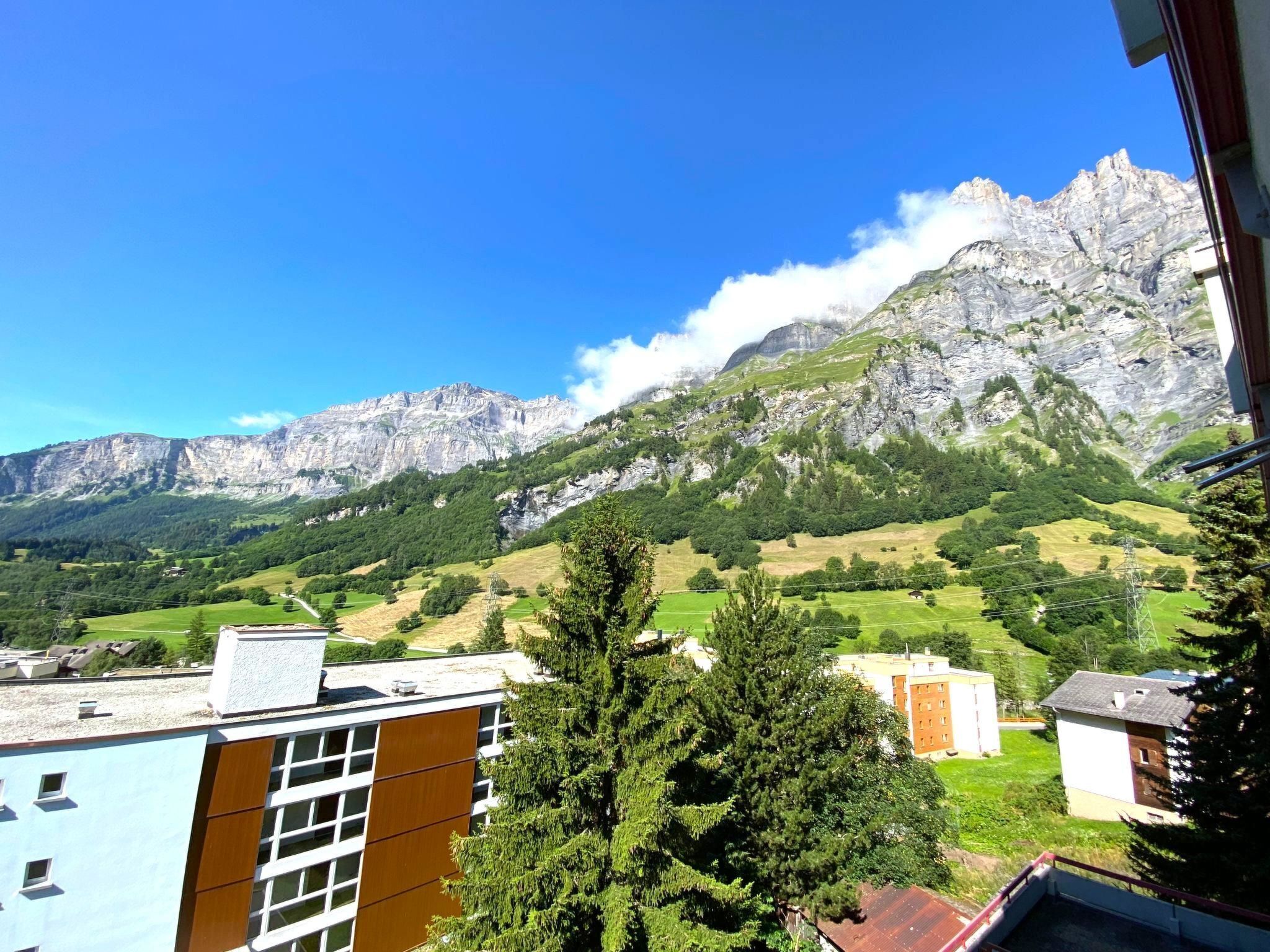 Eine Berglandschaft mit Gebäuden im Vordergrund.