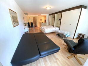 Une pièce comprenant un lit, une table de massage, une chaise, un bureau et une armoire.