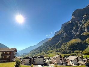 Ein Wohngebiet mit modernen Gebäuden, blauem Himmel und Bergelandschaft im Hintergrund.