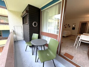 A balcony with a table and chairs, a small fireplace, and a view of the outside. - Fortuna 220 # 2-bed apartment, Dusche, WC 2-Bettwohnung, Dusche, WC by Interhome (Leukerbad)