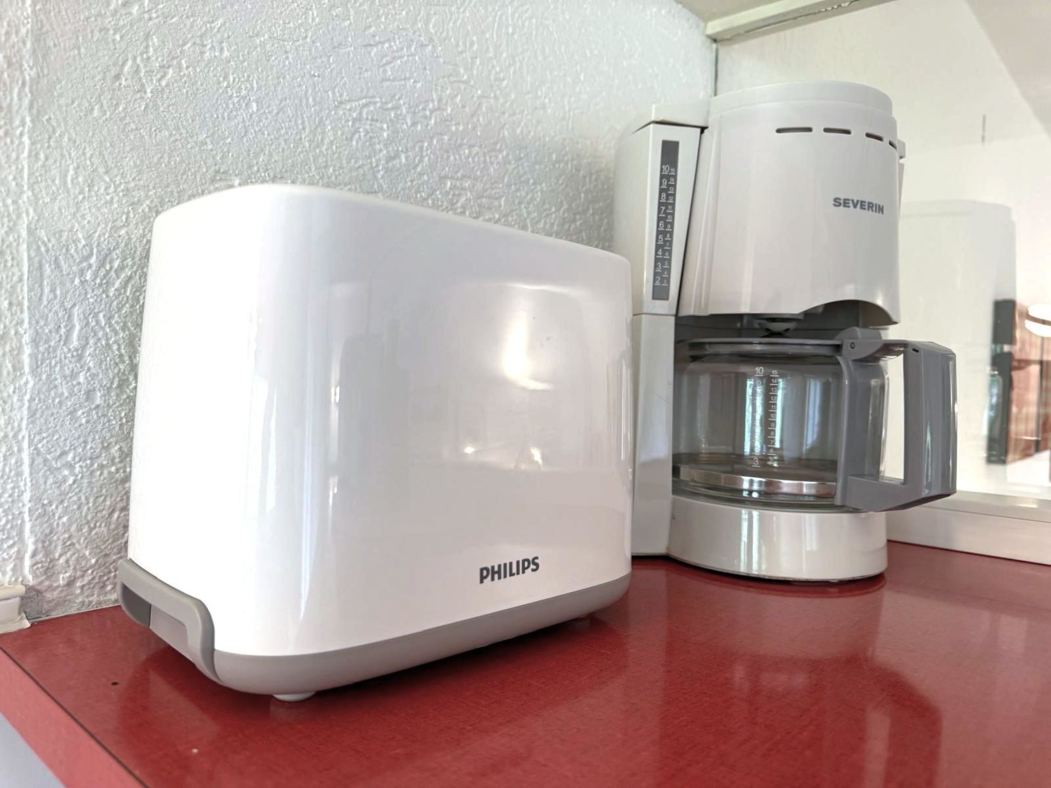 Eine weiße Philips-Kaffeemaschine und eine weitere Kaffeemaschine auf einer Arbeitsplatte.