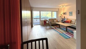 A spacious living area with a sofa, chairs, a coffee table, and a view of a balcony. - Salve 8 # 5-bed apartment, Bad, WC 5-Bettwohnung, Bad, WC by Interhome (Leukerbad)