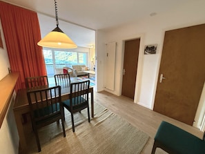 Een eetruimte met een tafel, stoelen en een hanglamp.