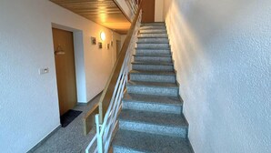 A staircase with a wooden handrail and a door at the top. - Salve 8 # 5-bed apartment, Bad, WC 5-Bettwohnung, Bad, WC by Interhome (Leukerbad)