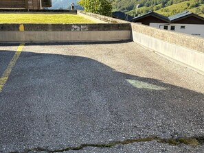 Ein gepflasterter Bereich mit einer Betonbarriere und ein Gebäude im Hintergrund, auf dem 'OLYMPIA' steht.