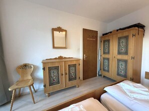 A bedroom with a wooden wardrobe, a chair, and a bed. - Salve 9 # 6-bed apartment, Dusche, WC 6-Bettwohnung, Dusche, WC by Interhome (Leukerbad)