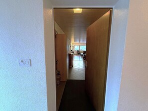A narrow hallway leading to a living area with a dining table and chairs. - Salve 9 # 6-bed apartment, Dusche, WC 6-Bettwohnung, Dusche, WC by Interhome (Leukerbad)