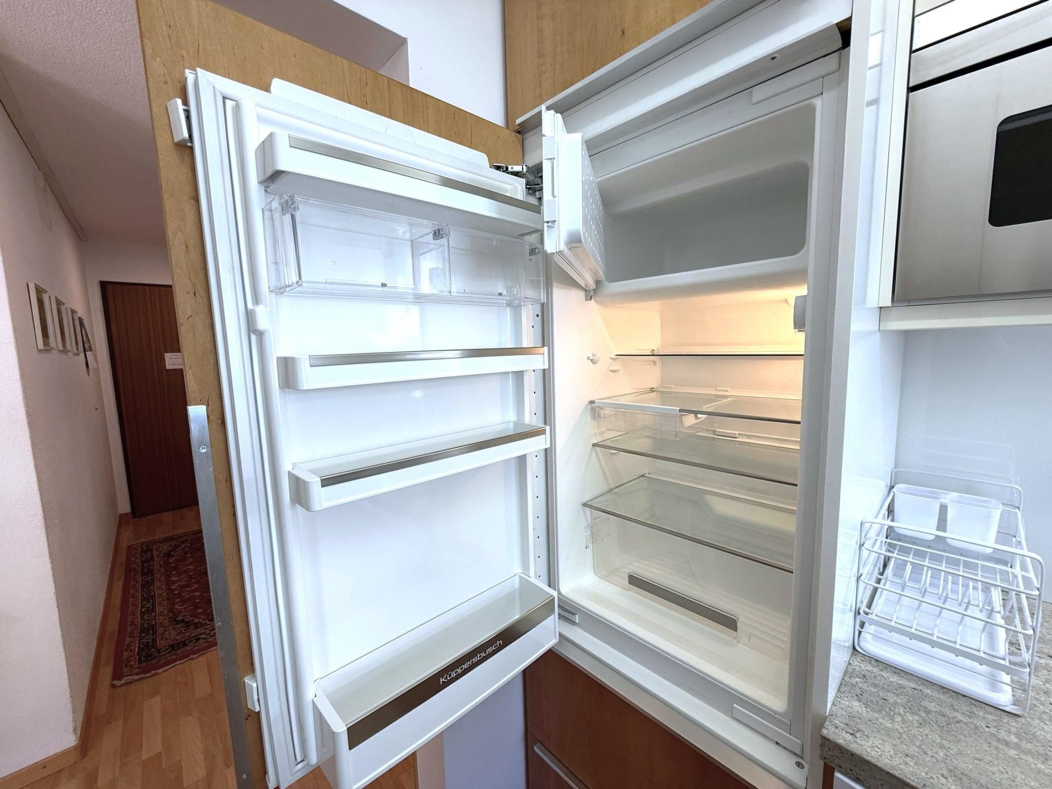 Eine moderne Küche mit Einbaukühlschrank, Holzschränken und einer Kochinsel.