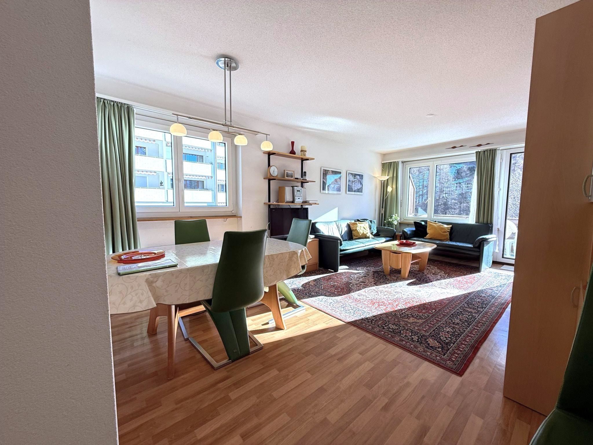 A modern living room with a dining area, a sofa set, and a TV.