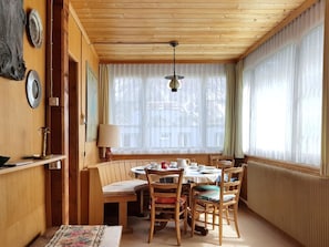 Ein gemütlicher Essbereich mit Holztisch, Stühlen und einer Pendelleuchte.