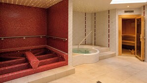 A spa area with a red-tiled wall, a wooden sauna, and a glass-enclosed hot tub. - Ambassador Leukerbad # 4-bed apartment, Dusche und Bad, WC by Interhome (Leukerbad)