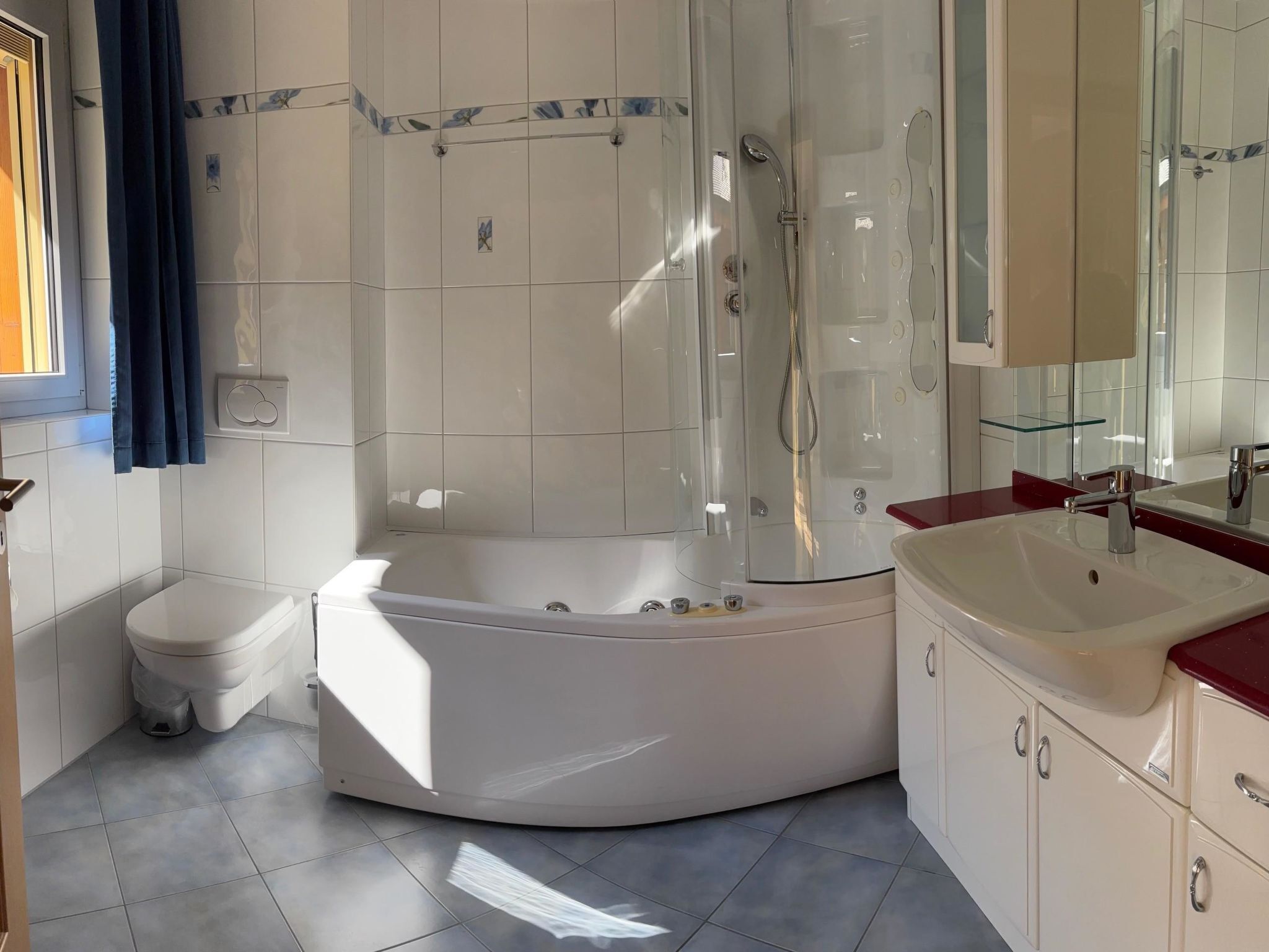 A modern bathroom with a freestanding bathtub, a toilet, and a sink with a mirror.