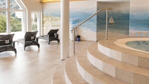 A spacious indoor area with a wooden ceiling, a curved staircase leading to a hot tub, and a mural of a beach scene. - Ambassador Leukerbad # 4-bed apartment, Dusche und Bad, WC by Interhome (Leukerbad)