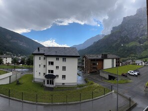 A multi-story building with a flat roof, surrounded by a grassy area and a parking lot. - Residenz Siesta Leukerbad # 5-bed apartment, Bad, WC by Interhome (Leukerbad)