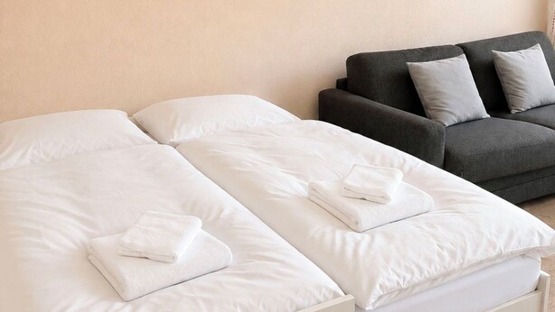 Ein Hotelzimmer mit einem Bett, einer Couch und einer Wand.