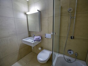 Un bagno con lavandino, WC e doccia.