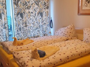 Ein Hotelzimmer mit Bett, einem Vorhangfenster und einem wandmontierten Telefon.