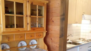 Una cocina de madera con un armario empotrado, un fregadero y un salpicadero de azulejos.