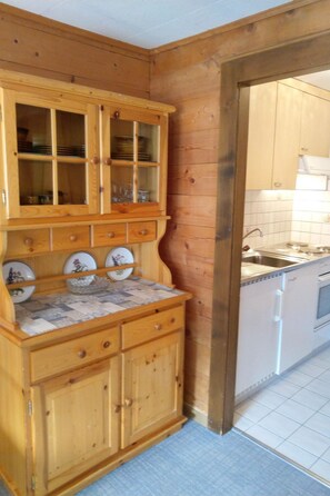 A wooden kitchen with a built-in cabinet, a sink, and a tiled backsplash. - Gassenboden 32 # 2-bed apartment, Dusche, WC 2-Bettwohnung, Dusche, WC by Interhome (Leukerbad)