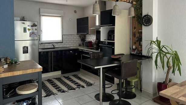 A modern kitchen with a dining area, a refrigerator, a sink, and a window. - House with a garden in Candillargues (Candillargues)