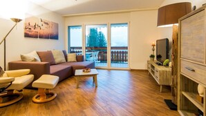 A spacious living room with a sofa, a coffee table, and a television. - Ambassador B13 # 4-bed apartment, Dusche und Bad, WC by Interhome (Leukerbad)
