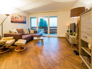 A spacious living room with a sofa, a coffee table, and a television. - Ambassador B13 # 4-bed apartment, Dusche und Bad, WC by Interhome (Leukerbad)