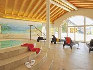 A spa area with a hot tub, seating, and a view of the mountains. - Ambassador B13 # 4-bed apartment, Dusche und Bad, WC by Interhome (Leukerbad)