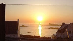 A sunset over a body of water with buildings in the foreground.