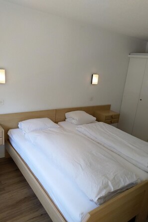 A hotel room with a large bed, bedside tables, and a wardrobe. - Fortuna 404 # 3-bed apartment, Dusche, WC 3-Bettwohnung, Dusche, WC by Interhome (Leukerbad)