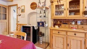 A cozy room with a wooden cabinet, a glass display case, and a red bedspread.