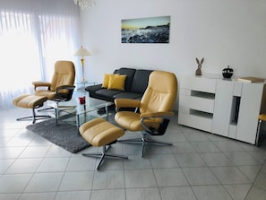 A modern living room with a sofa, two armchairs, a glass coffee table, and a white cabinet. - Edelweiss B 23 # 4-bed apartment, Dusche, WC 4-bed apartment, Dusche, WC by Interhome (Leukerbad)