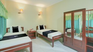 A hotel room with two beds, a wardrobe, and a nightstand. - Cozy Twin Escape With Free Wifi and Parking (Makassar)