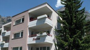 A multi-story building with balconies, a sign reading 'Salve,' and a large tree in the foreground. - Salve 3 # 4-bed apartment, Dusche, WC 4-Bettwohnung, Dusche, WC by Interhome (Leukerbad)