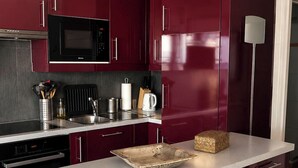 Una cocina moderna con armarios oscuros, microondas y horno empotrado.