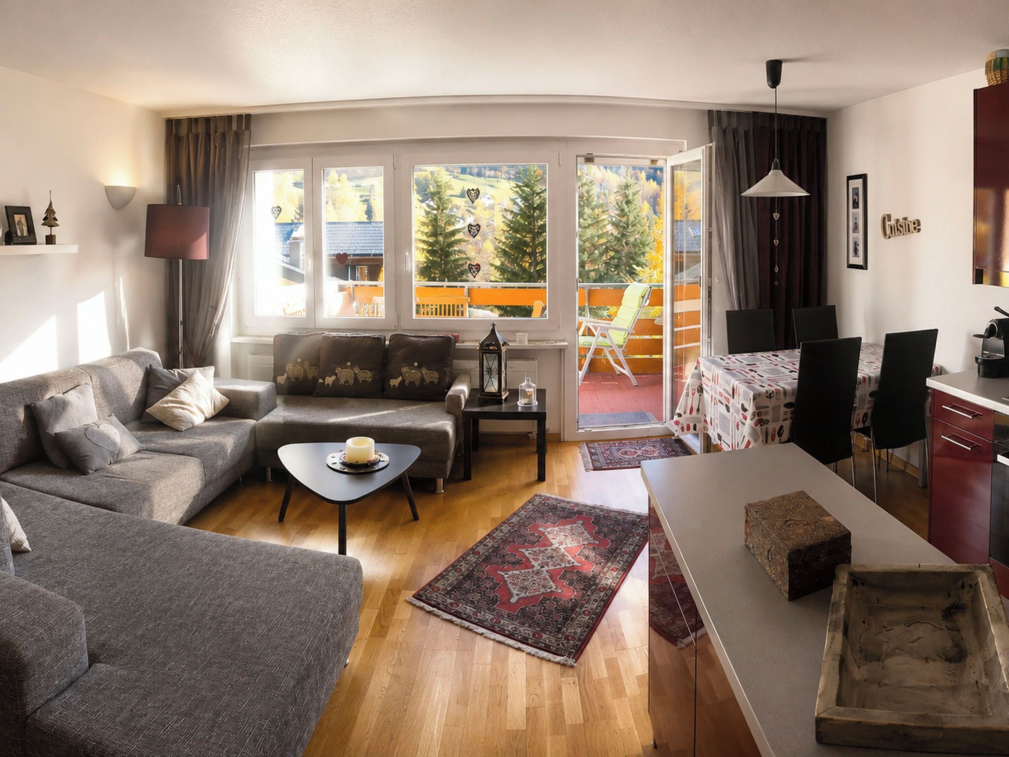 A modern living room with a sofa, a coffee table, and a dining area with chairs and a table.