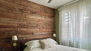 A bedroom with a wooden headboard, a bed with white linens, two bedside lamps, and a ceiling fan. - Sunset Villa Sleeps 10 Near Beach & SJU 4 bedroom Family House (Carolina)