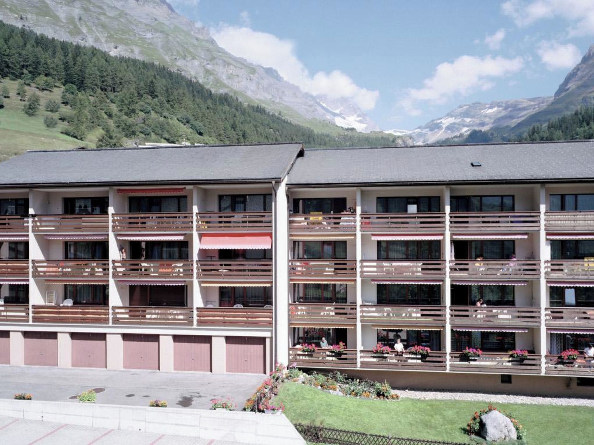 Un hôtel à plusieurs étages doté de balcons, d’un parking et situé dans un cadre montagneux.
