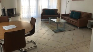 Ein modernes Wohnzimmer mit Esstisch, zwei Sofas und einem Couchtisch.