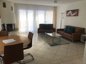 Ein modernes Wohnzimmer mit Esstisch, zwei Sofas und einem Couchtisch.