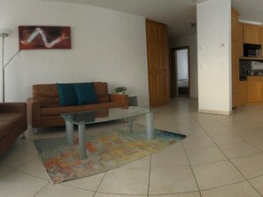 Ein Wohnzimmer mit einer Couch, einem Couchtisch und einem Gemälde an der Wand.