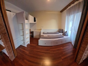 A bedroom with a bed, a desk, and a wardrobe. - Arca 2 # 5-bed apartment, Bad, WC 5-bed apartment, Bad, WC by Interhome (Leukerbad)