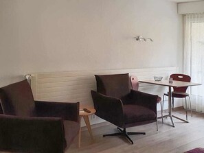 A room with a dining table, two chairs, a small side table, and a bench. - Fortuna 116 # 2-bed apartment, Dusche, WC 2-Bettwohnung, Dusche, WC by Interhome (Leukerbad)