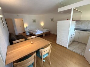 A compact living space with a bed, a small dining table, a kitchenette, and a sofa. - Fortuna 113 # 2-bed apartment, Dusche, WC 2-Bettwohnung, Dusche, WC by Interhome (Leukerbad)