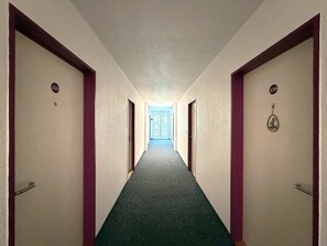 A corridor with doors numbered 113 and 118, leading to a room with a window. - Fortuna 113 # 2-bed apartment, Dusche, WC 2-Bettwohnung, Dusche, WC by Interhome (Leukerbad)