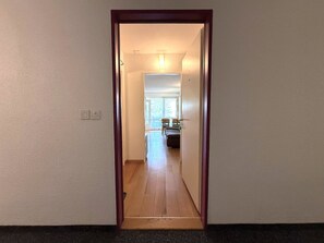 A narrow hallway leading to a room with a window and a door. - Fortuna 113 # 2-bed apartment, Dusche, WC 2-Bettwohnung, Dusche, WC by Interhome (Leukerbad)