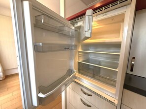 Ein offener Kühlschrank mit mehreren Ablagen und einem Gefrierfach.