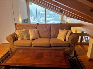 A cozy room with a sofa and a wooden coffee table. - Edelweiss B 41 # 4-bed apartment, Dusche und Bad, WC by Interhome (Leukerbad)