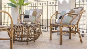 Wicker furniture with cushions on an outdoor balcony with a railing and a plant. - 3-guest Oasis With Scenic Terrace (Madrid)