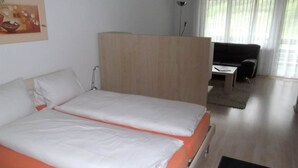 Une chambre d’hôtel avec un lit, un bureau et une chaise.