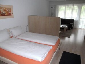 A hotel room with a bed, a desk, and a chair. - Valère Leukerbad # 2-bed apartment, Dusche, WC by Interhome (Leukerbad)